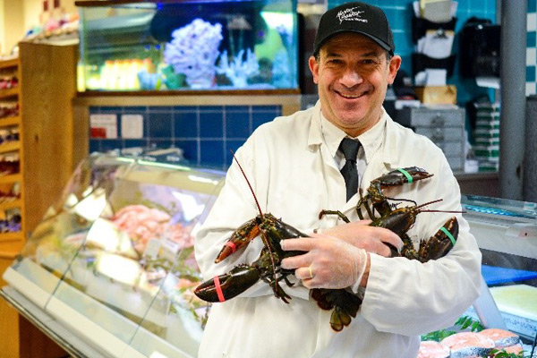Tony holding two lobsters in the Seafood department